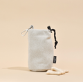 Light beige tweed drawstring dog treat pouch with a carabiner on a beige background